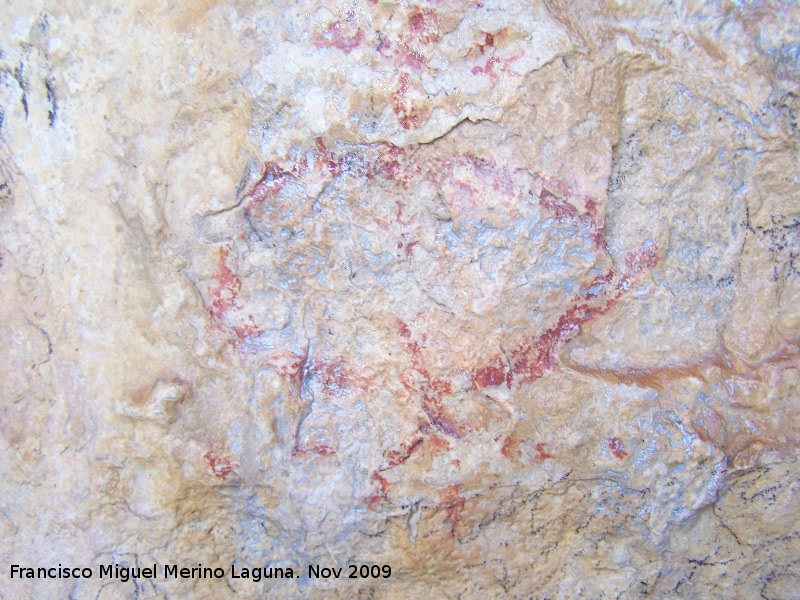 Pinturas rupestres de la Cueva de la Graja-Grupo III - Pinturas rupestres de la Cueva de la Graja-Grupo III. Antropomorfo tipo phi con adorno en la cabeza y pene, una serie de puntos en sentido horizontal y a la altura de sus piernas están ambos lados de la figura